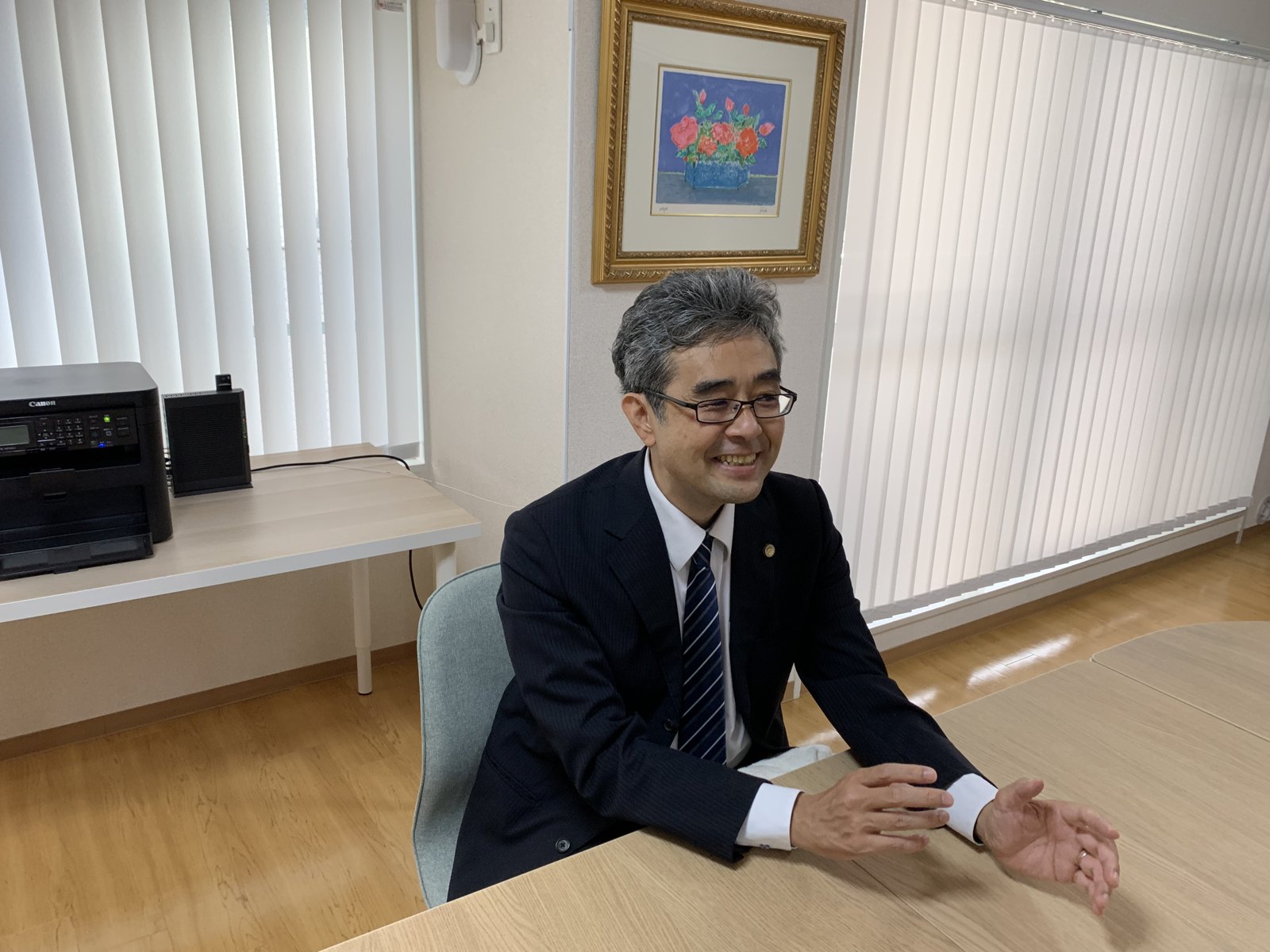 笑顔で話をする杉山弘剛弁護士